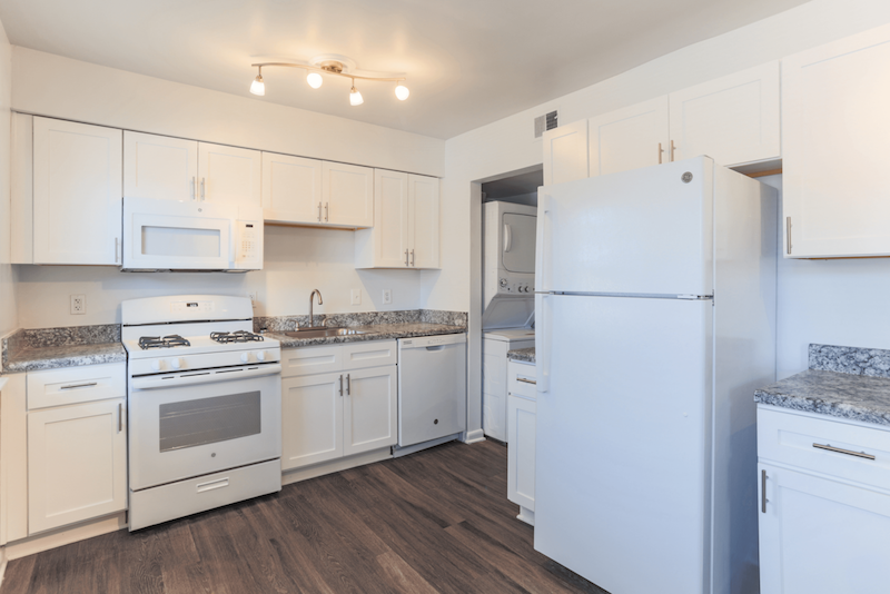 kitchen with white appliances and a full size stacked washer and dryer